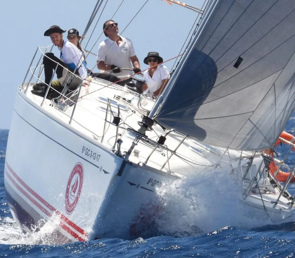 El velero ALAIA II navegando escorado con invitados a bordo
