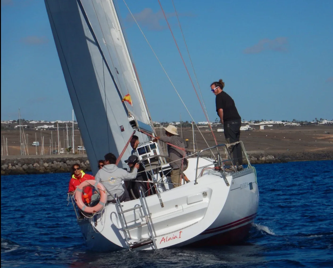 Popa del velero ALAIA I, Jeanneau Sun Fast 39, navegando con invitados a bordo frente a Arrecife