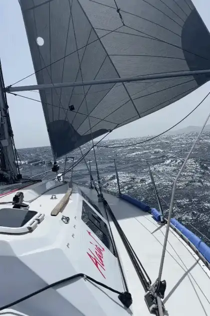 Las velas del ALAIA hinchadas por el viento, a contraluz
